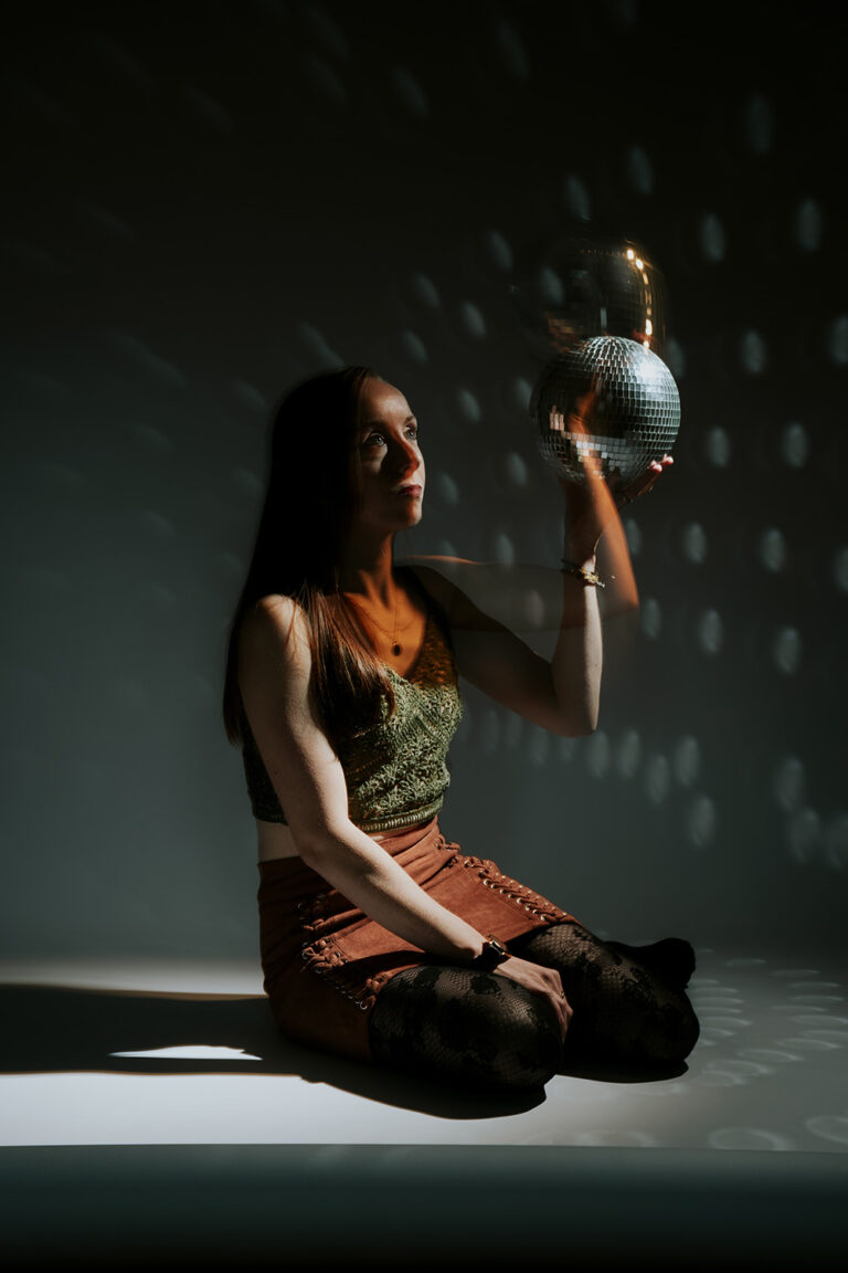 Femme en studio portrait avec boule à facette.